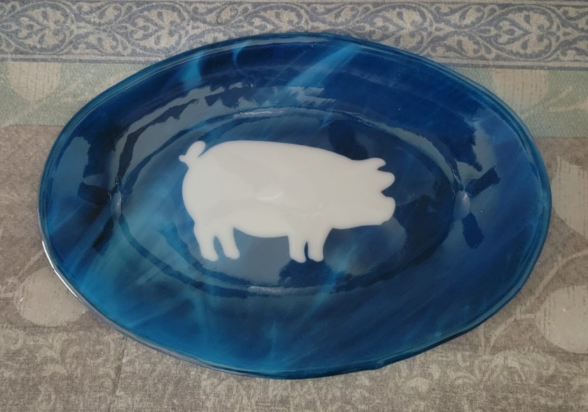 Blue glass plate with white pig silhouette