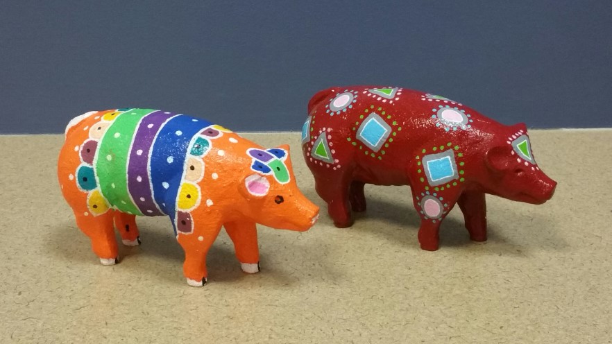 Two colorful painted pig figurines