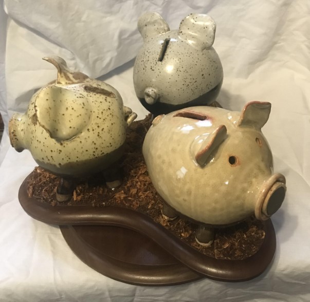 3 ceramic piggy banks on a spinning platform